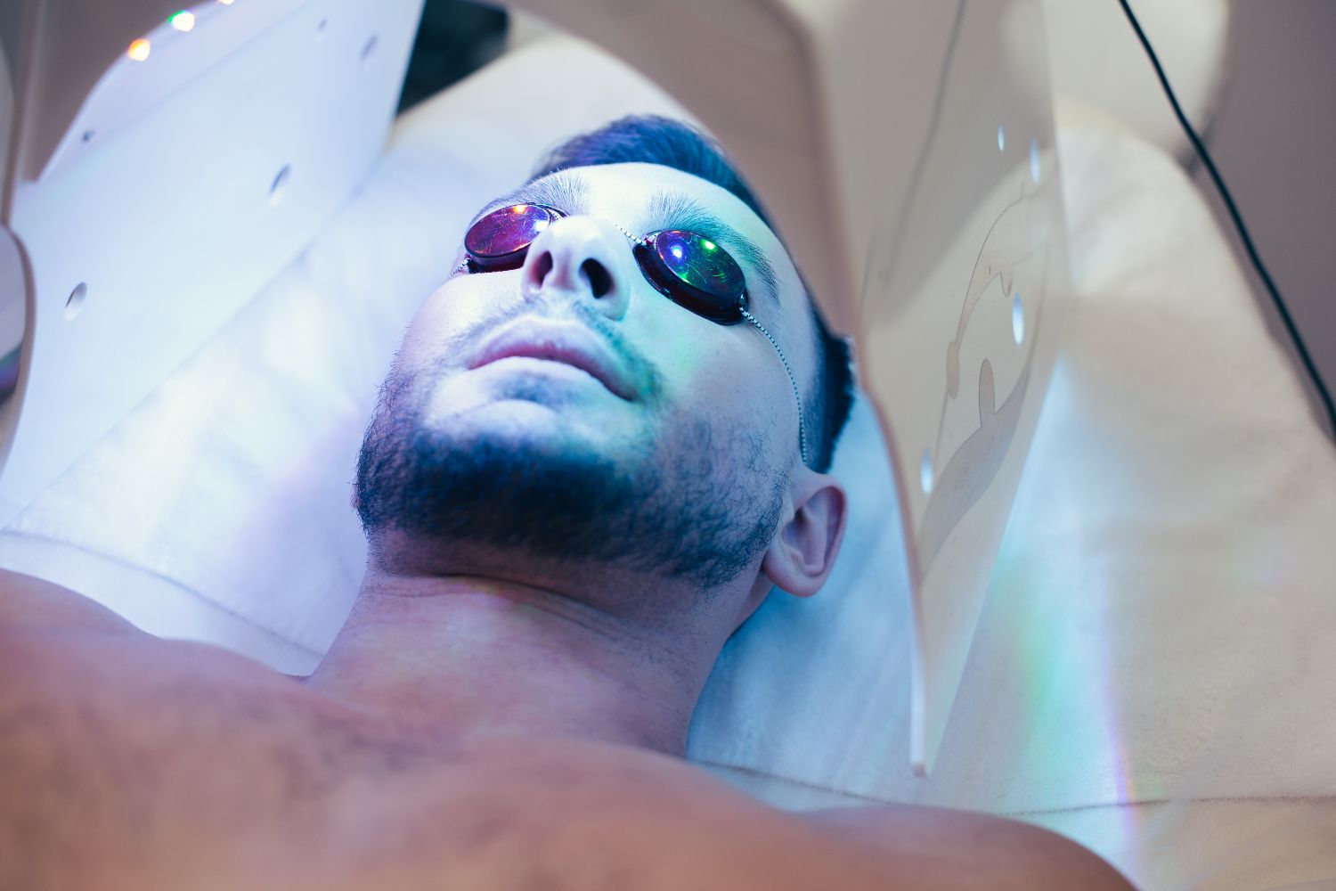 Hombre con gafas protectoras en la cara y broncearse en el solarium